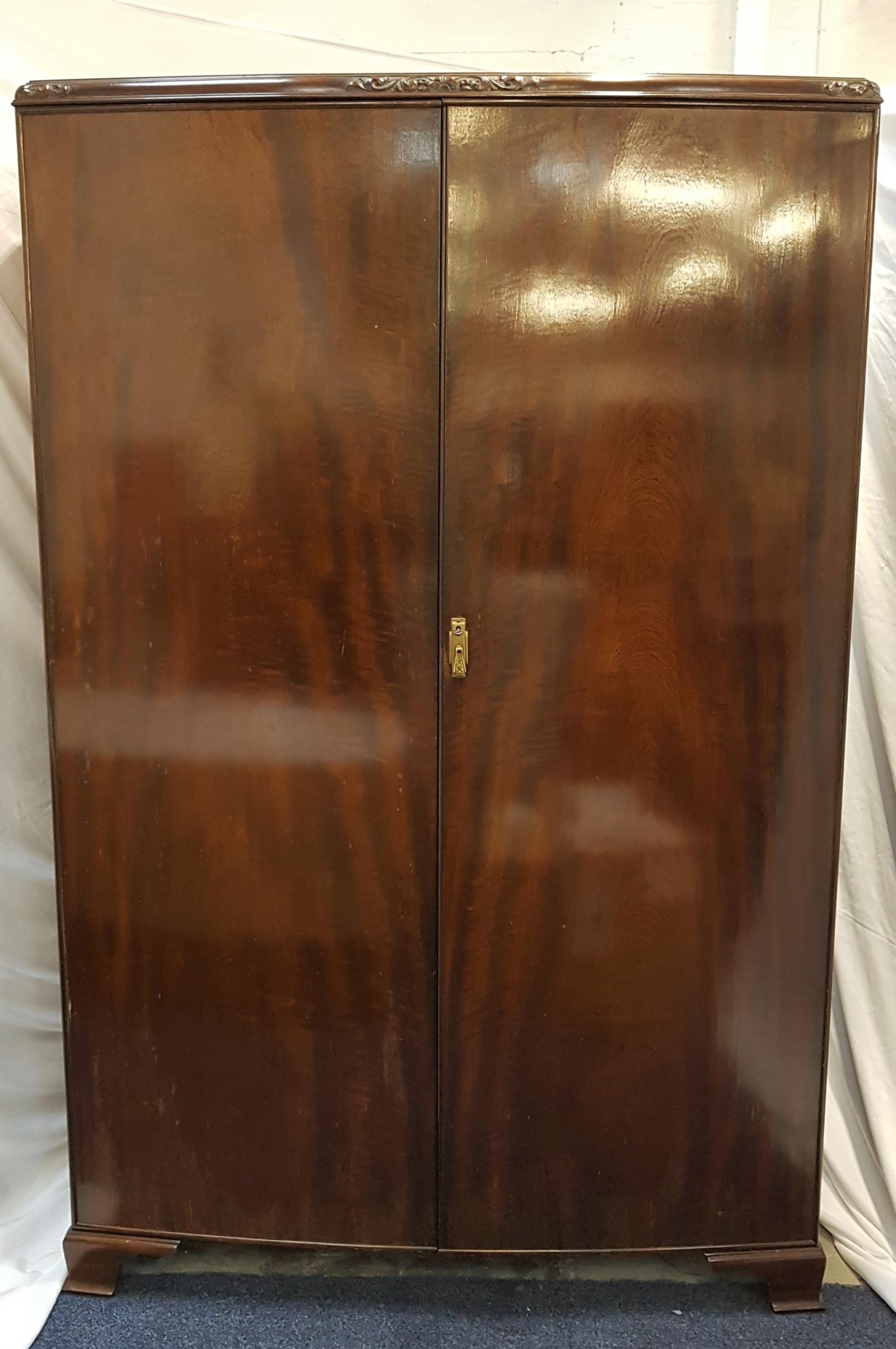 MAHOGANY TWO DOOR WARDROBE with an internal door mounted mirror, shelf and hanging rail, standing on