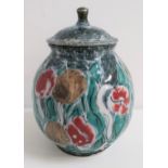 HIGHLAND STONEWARE JAR AND COVER decorated with tulips, 24cm high