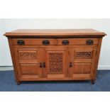 EDWARDIAN LIGHT OAK SIDEBOARD with a moulded top above two panelled frieze drawers with three carved