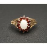 OPAL AND GARNET CLUSTER RING the central oval cabochon opal in twelve garnet surround, on nine carat