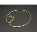 MINIMALIST EIGHTEEN CARAT GOLD HINGED BANGLE with safety chain, approximately 5.4 grams