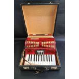 DIBORA ACCORDIAN with a mottled red body in a fitted case