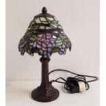 TIFFANY STYLE TABLE LAMP with a domed shade with opaque green, mauve and white glass, 32cm high