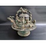 19th CENTURY MALAY BRONZE KETTLE with a fold over lizard decorated handle with grotesque figures