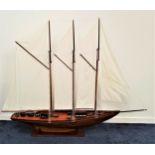 SCALE MODEL OF A SCHOONER with three masts and rigging, of teak construction with stand, 201cm long
