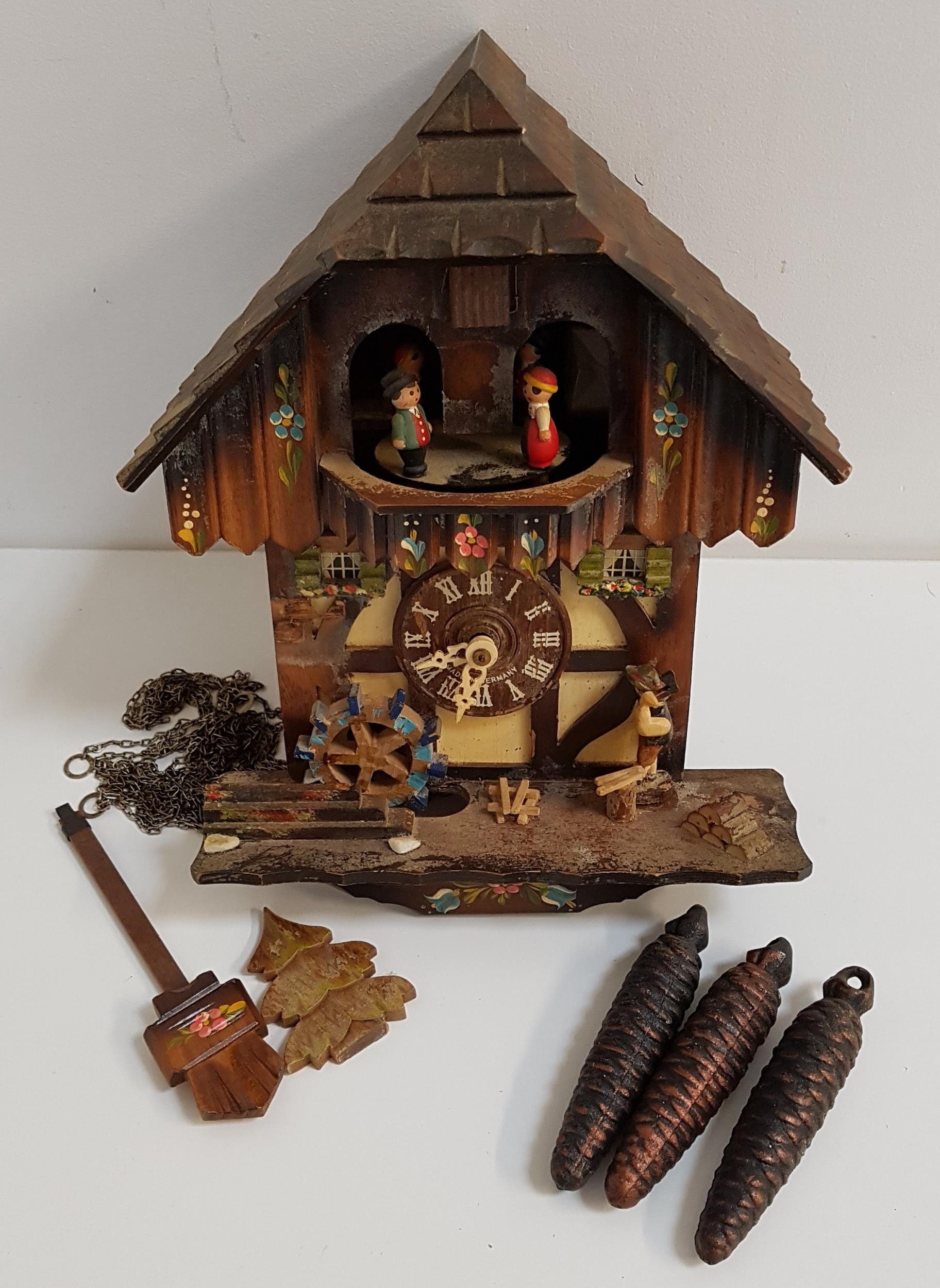 BLACK FOREST CUCKOO CLOCK the circular dial with roman numerals, with pendulum and weights