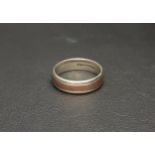 NINE CARAT GOLD BAND the white gold ring with central band of rose gold, approximately 6.8 grams,