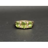 PERIDOT AND SEED PEARL THREE STONE RING the three graduated oval cut peridots measuring