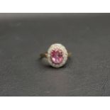 PINK TOPAZ AND DIAMOND CLUSTER RING the central oval cut topaz approximately 0.75cts in a sixteen