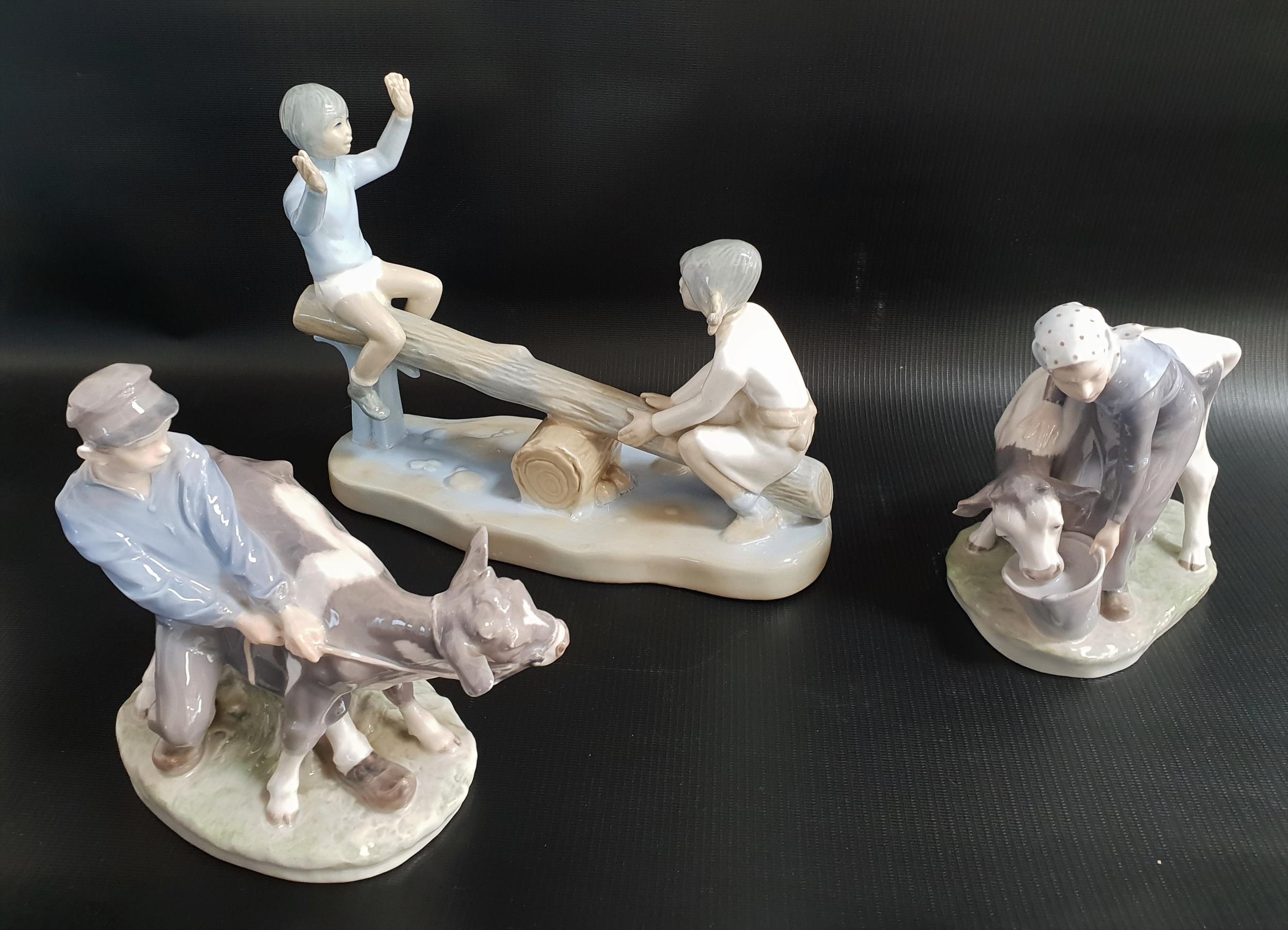 TWO ROYAL COPENHAGEN PORCELAIN GROUPS designed by Christian Thomsen depicting a girl and calf,