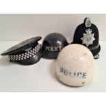 FOUR POLICE HATS including a peaked cap with the Northumberland force badge and black rain cover,