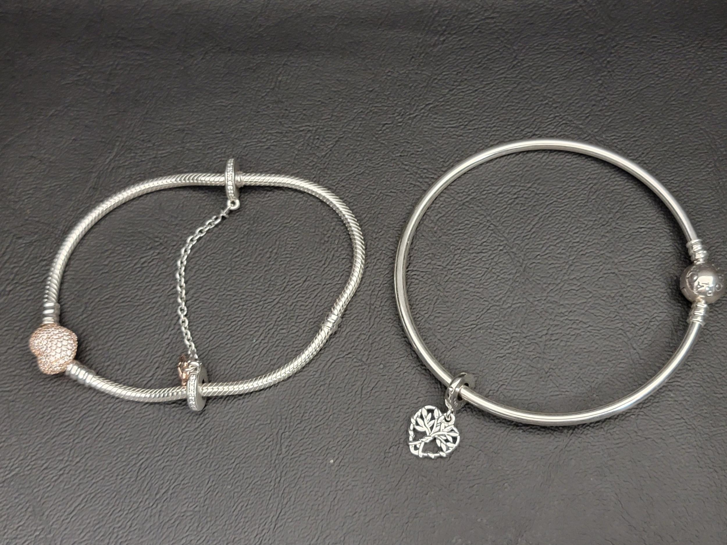 TWO PANDORA BRACELETS comprising a Pandora Moments Bangle with a Heart Family Tree Dangle Charm