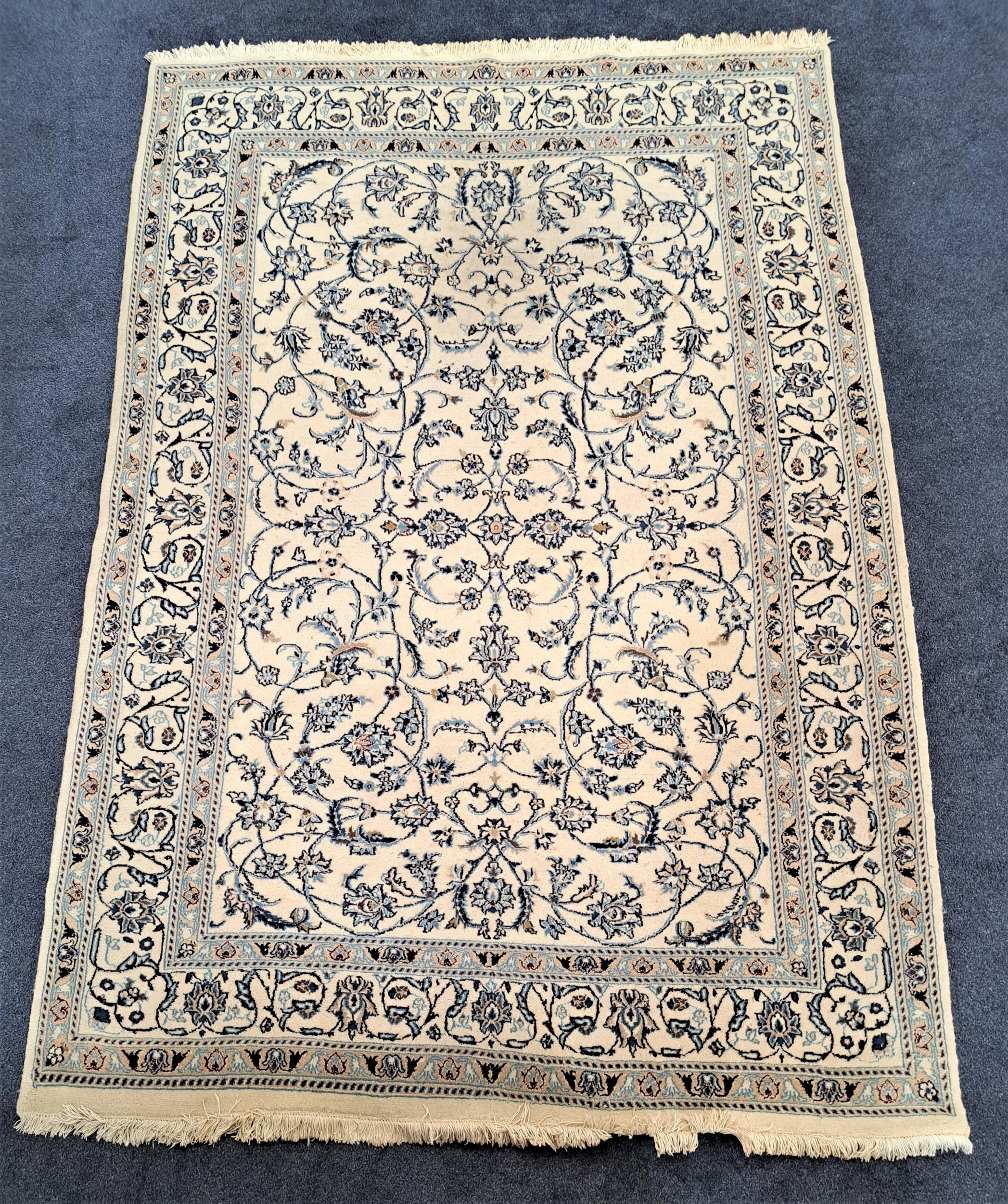 NAIN RUG with a cream ground and blue floral entwined pattern, 286cm x 197cm