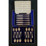 SET OF TWELVE GEORGE V SILVER TEA SPOONS and a pair of sugar tongs in a fitted case, Sheffield