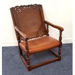 OAK MONKS CHAIR with a slide and fold-over carved and shaped back above shaped arms on turned