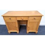 WAXED PINE KNEEHOLE DESK with a moulded top above three frieze drawers and two panelled cupboard
