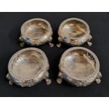 SET OF FOUR VICTORIAN SILVER SALTS decorated with embossed floral decoration and raised on paw feet,
