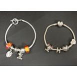 TWO PANDORA SILVER CHARM BRACELETS comprising a heart clasp snake chain bracelet with four charms