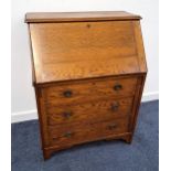 OAK BUREAU with a fall flap opening to reveal a fitted interior above three graduated drawers,