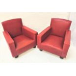 PAIR OF CLUB ARMCHAIRS covered in red vinyl, standing on flattened bun feet with castors (2)
