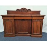 19th CENTURY MAHOGANY INVERTED BREAKFRONT SIDEBOARD with a carved raised back above three frieze