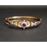 ATTRACTIVE AMETHYST AND SEED PEARL BANGLE early 20th century, in nine carat gold with pierced