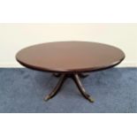 MAHOGANY OCCASIONAL TABLE with an oval top on a central column with four outswept supports with