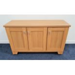 WOODBERRY BROTHERS LIGHT OAK SIDE CABINET with a rectangular top above three panelled doors,