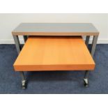 BEECH OCCASIONAL TABLE with a square top standing on tubular metal legs with casters, 80cm wide,