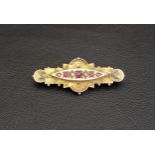 VICTORIAN RUBY AND SEED PEARL BROOCH in nine carat gold, with rope twist scroll decoration, 4.3cm