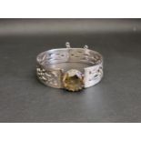 SCOTTISH SILVER BANGLE with central round cut citrine flanked by pierced Celtic motif decoration,