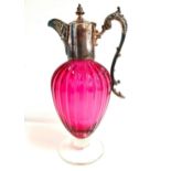 LATE VICTORIAN CRANBERRY GLASS CLARET JUG with a lobed body and silver plated mounts, raised on a