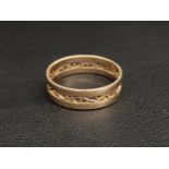 FOURTEEN CARAT GOLD RING with a central pierced floral motif band and decorative edges,