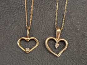 TWO TEN CARAT GOLD HEART SHAPED PENDANTS both with a single diamond and on a ten carat gold chain,