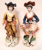 PAIR OF CONTINENTAL POTTERY FIGURINES depicting a man and lady in 19th century dress, raised on