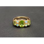 PRETTY PERIDOT AND OPAL DRESS RING the central oval cut peridot approximately 1ct, flanked by two