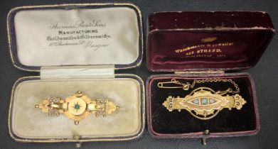 TWO VICTORIAN NINE CARAT GOLD BROOCHES one set with three graduated opals and with safety chain; the