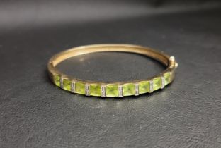 PERIDOT AND DIAMOND BANGLE the peridots separated by small diamonds, in nine carat gold and with