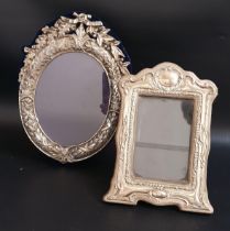 TWO SILVER PHOTOGRAPH FRAMES both with ornate frames, the oval example London 1988 by M & LS, 25.5cm