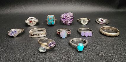 SELECTION OF TWELVE SILVER RINGS including a shaped Malcolm Gray example, an amethyst and blue topaz