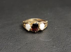 GARNET AND OPAL THREE STONE RING the central oval cut garnet approximately 0.75cts flanked by an