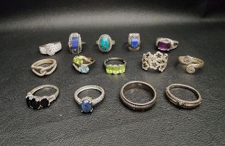 SELECTION OF FOURTEEN SILVER RINGS including a blue topaz and peridot twist design ring, a peridot