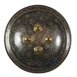 A circular convex metal shield or dhal, the obverse decorated with gilded and niello scrolling