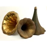Three gramophone horns, two brass and one painted white metal, the largest 24" (61cm)high, 23" (