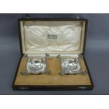 Omar Ramsden - A pair of silver salts with scroll handles, square lobed bodies on four ball feet