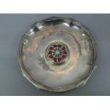 Omar Ramsden - A twelve sided silver dish with open work Tudor Rose motif in red enamels to centre