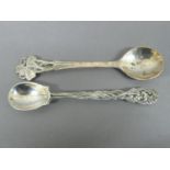 Omar Ramsden - two cast silver condiment spoons Shamrock and Iris decoration. London 1923 & 1932.