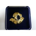 18 ct. gold feather brooch with diamond borders and belt - 10.2 grammes - length 4.5 cms