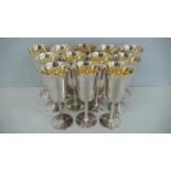 A set of twelve silver gilt wine goblets with flared tops, bark stems and circular foot - Birmingham