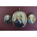 Three well painted Georgian oval miniatures of men set in gold frames - largest ht. 2.6 ins